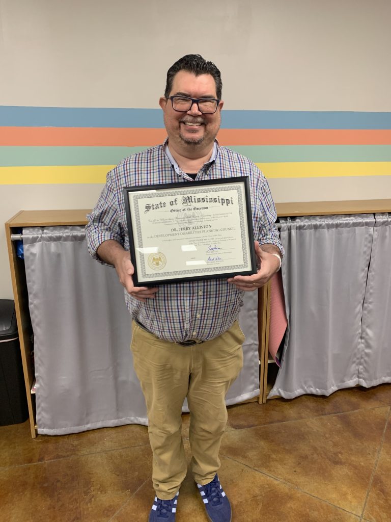 Interim Executive Director Dr. Jerry Alliston holding certificate of appointment to MSCDD