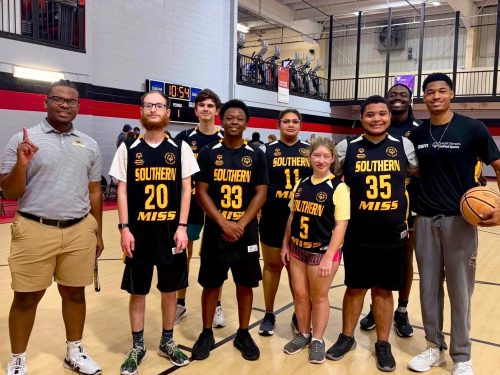 SO College Athletes posing in YMCA basketball court after the game.