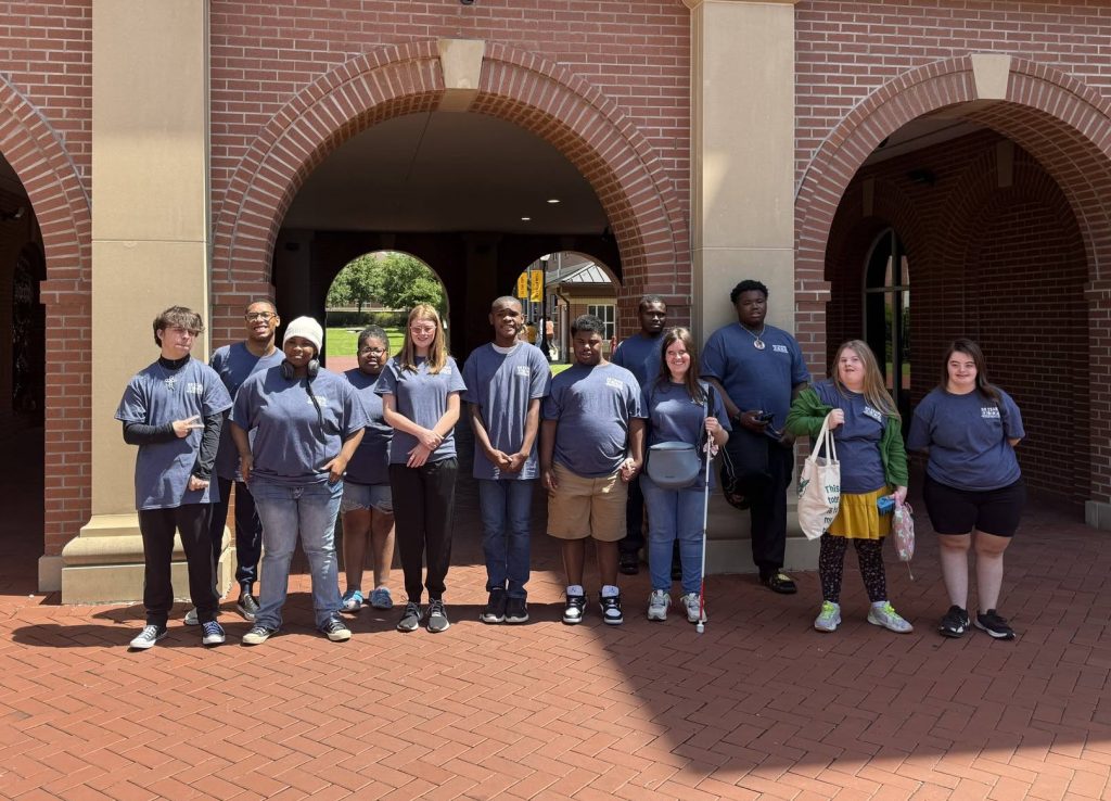 Students participating in the 2026 Summer Enrichment Academy pose in front of Luckyday Hall wearing their 50th Anniversary IDS tee shirts.